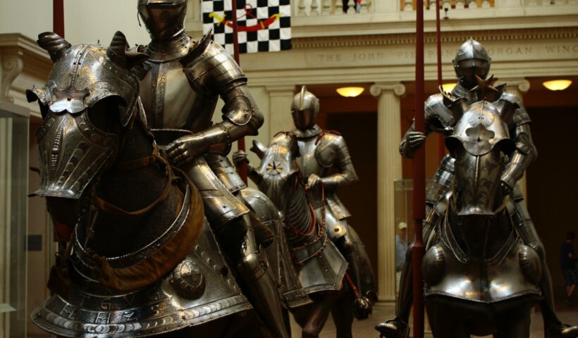 3 men in gold and black suit statue